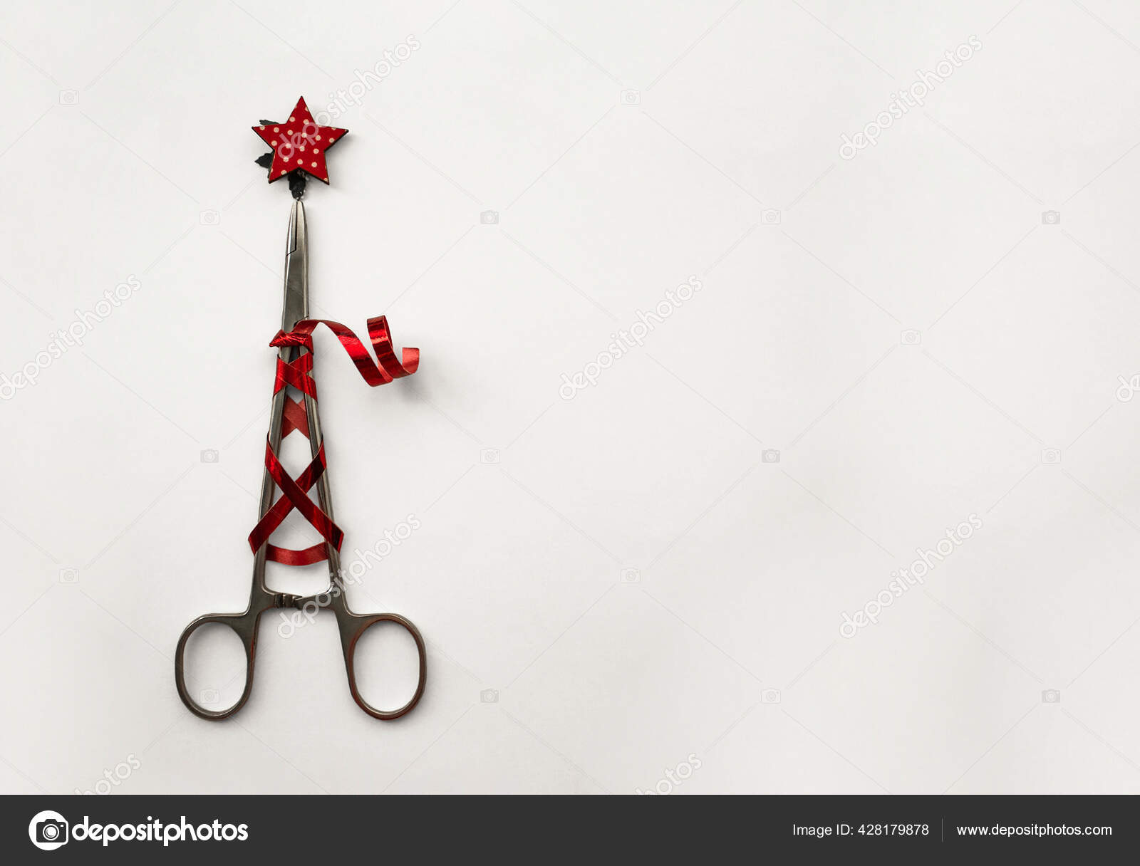 Surgical clip with festive red ribbon and star. Christmas tree made of  surgical instruments on a white background with space for text.  Minimalistic banner for congratulating doctors on the New Year Stock